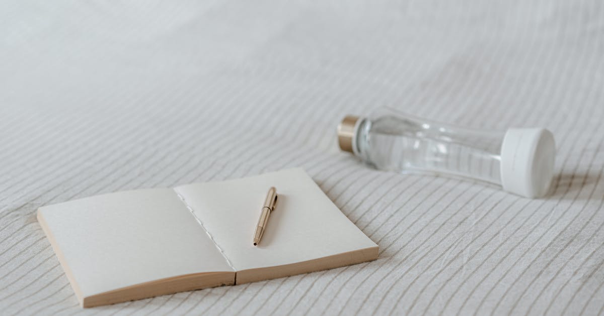 How to open this plastic cap? - Empty notepad near decorative bottle on bed