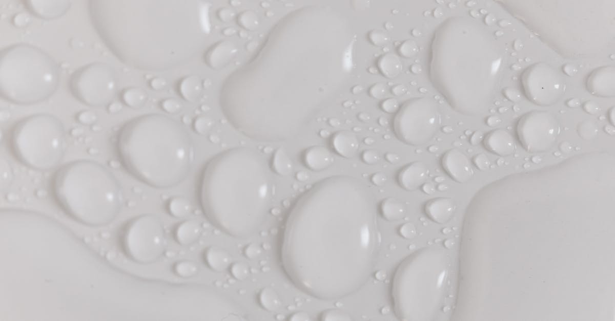 How to pack items that may leak liquids for lunch? - Closeup top view of wet plain white background of droplet with translucent clean still water drops of different shapes and sizes