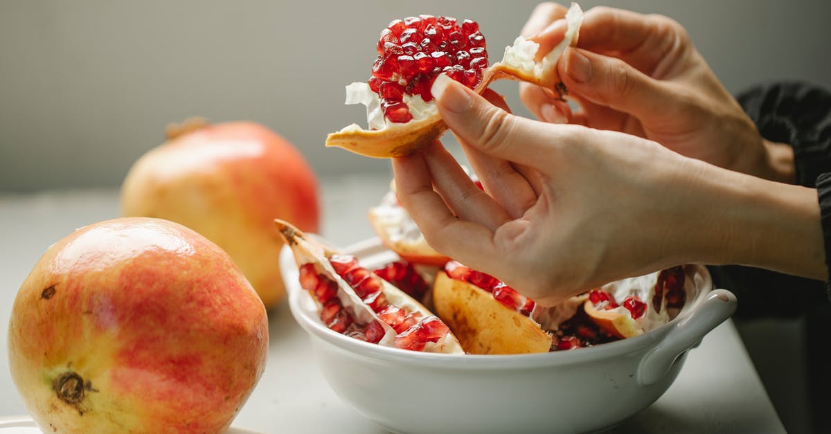 how to peel a pomegranate efficiently? - Woman taking off peel from ripe pomegranate