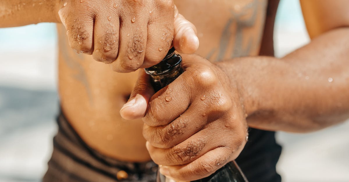 How to pop a tiny champagne cork? - Close-Up Photo of Person Opening a Champagne Bottle