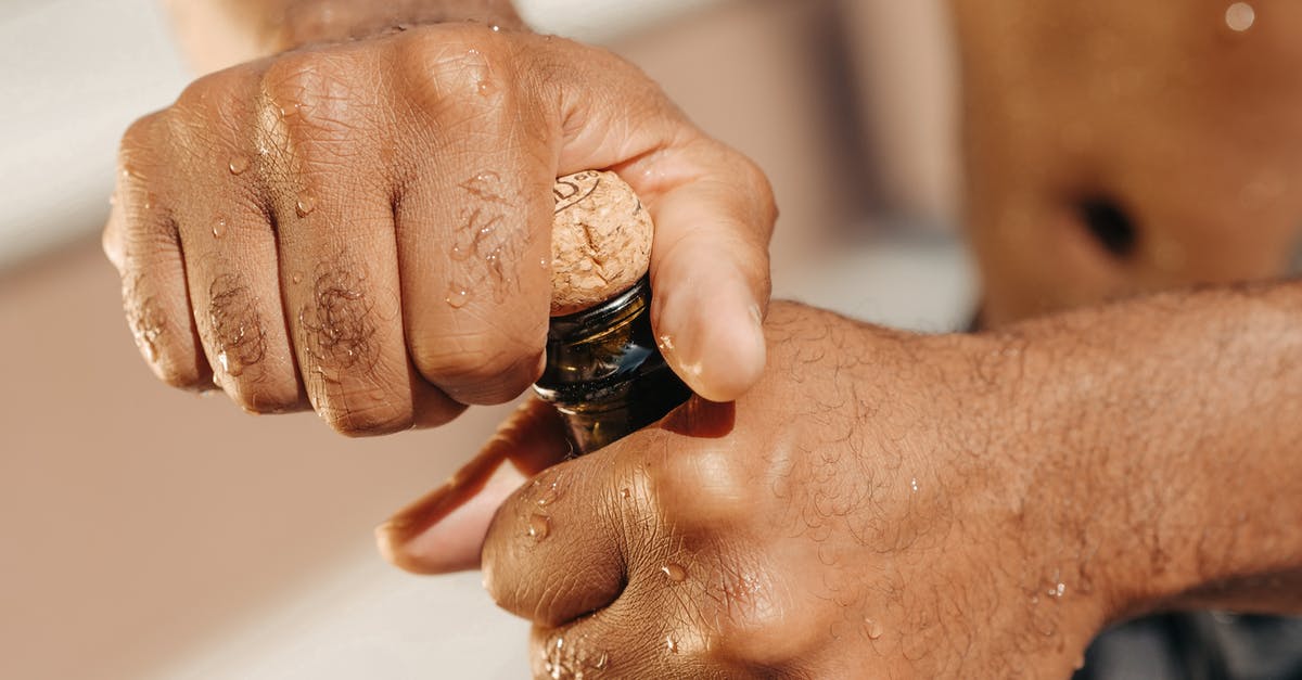 How to pop a tiny champagne cork? - Close-Up Photo of Person Opening a Champagne Bottle