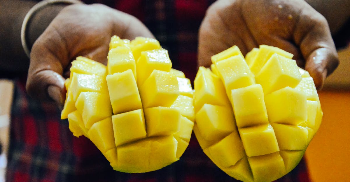 How to prepare summer squash without the peel becoming rubbery - Ethnic person showing bright cut mango