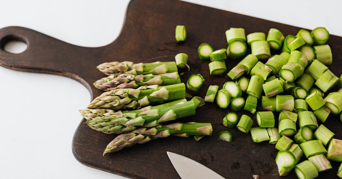 How to prevent calzones from getting soggy on steam table? - Bunch of asparagus and knife on cutting board