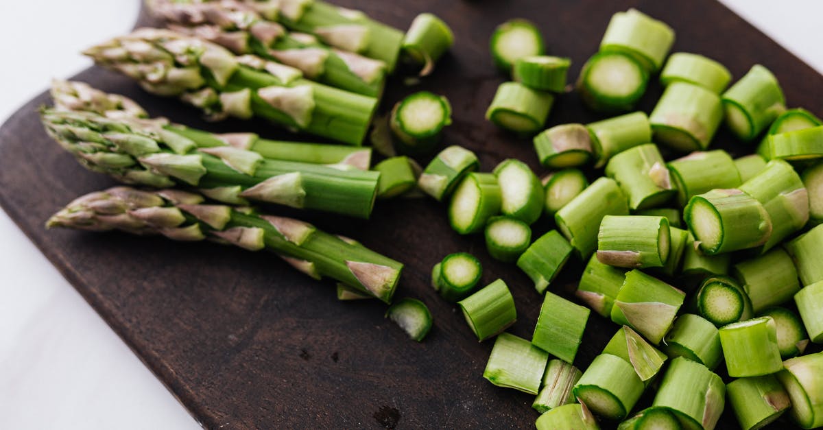 How to prevent calzones from getting soggy on steam table? - Closeup of green chopped stems of asparagus placed on wooden cutting board on white surface