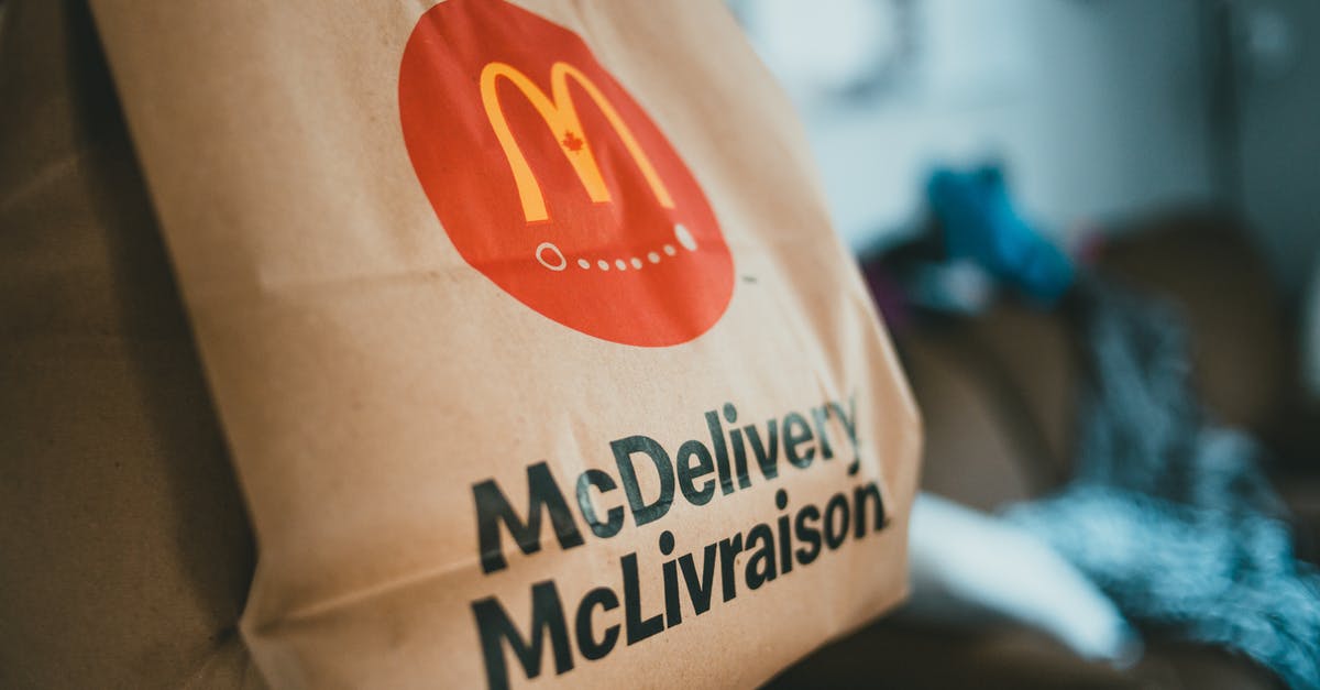 How to prevent fat splashes when I fry a burger? - Brown packet with hot fresh food delivered at home on blurred background in daytime