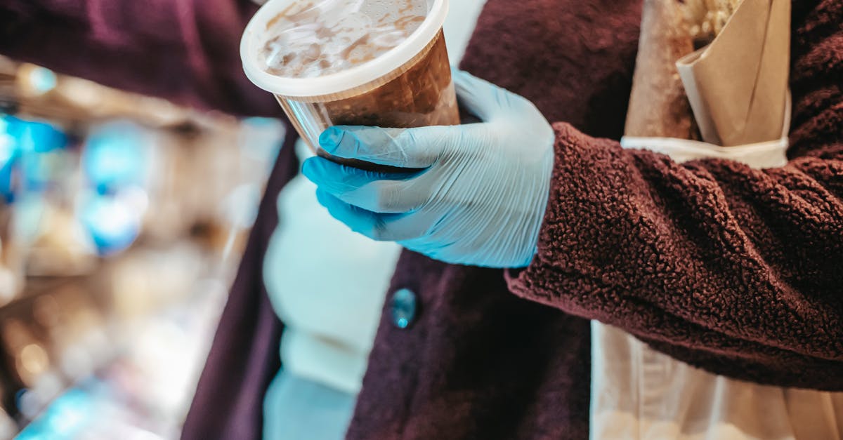 How to prevent frozen food from freeze-drying? - Crop anonymous female buyer in gloves with plastic container of frozen food in grocery store during coronavirus pandemic