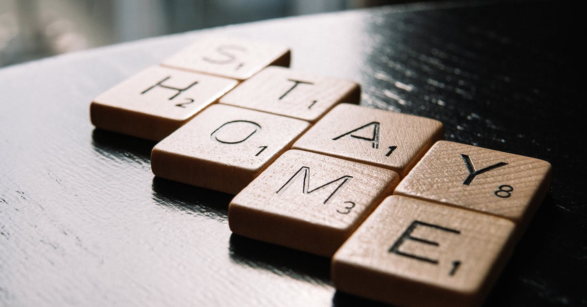 How to prevent home-made apricot marmalade from going mouldy - High angle of scrabble letter tiles arranged on black wooden table in inscription Stay Home in living room