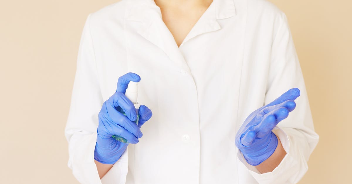 How to prevent liquid-y marinara sauce - Crop unrecognizable hospital worker in white uniform spraying antiseptic liquid over hands in blue latex gloves