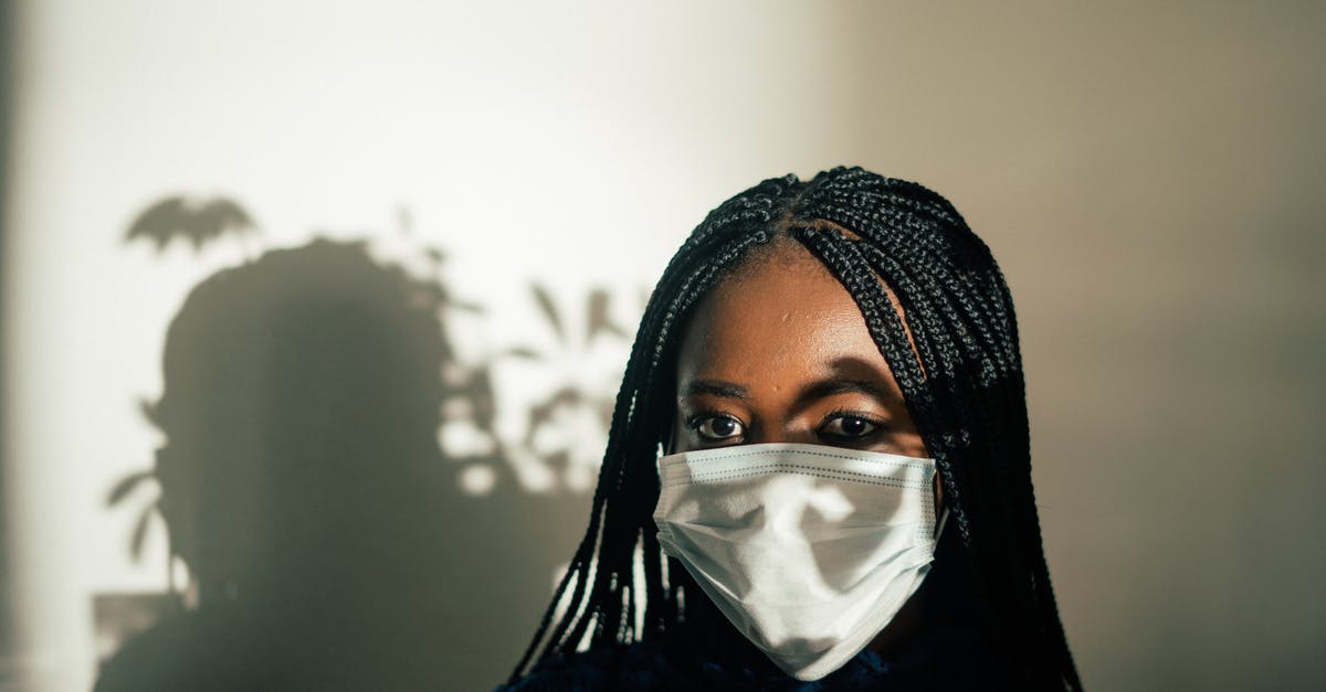 How to prevent "sweating" chocolate covered strawberries? - Unrecognizable African American female in medical mask against white wall with shadow of leaves plant on face