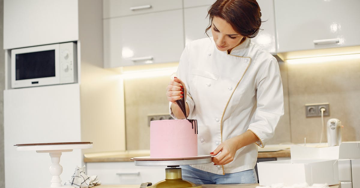 How to "fill" a cake made from a cupcake recipe - Concentrated female pastry cook decorating cake with pleasure in modern restaurant