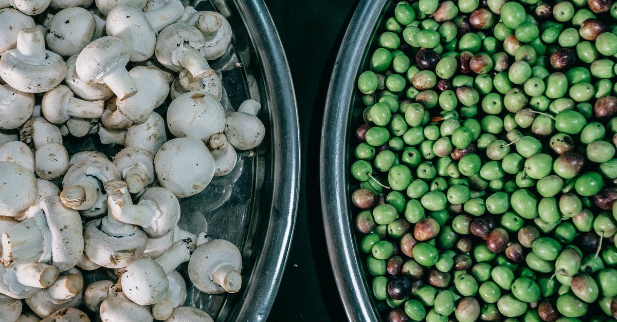 How to reduce Phytate in pea protein isolate? - Top view composition of ripe raw green peas and fresh mushrooms heaped in steel bowls and placed on dark table
