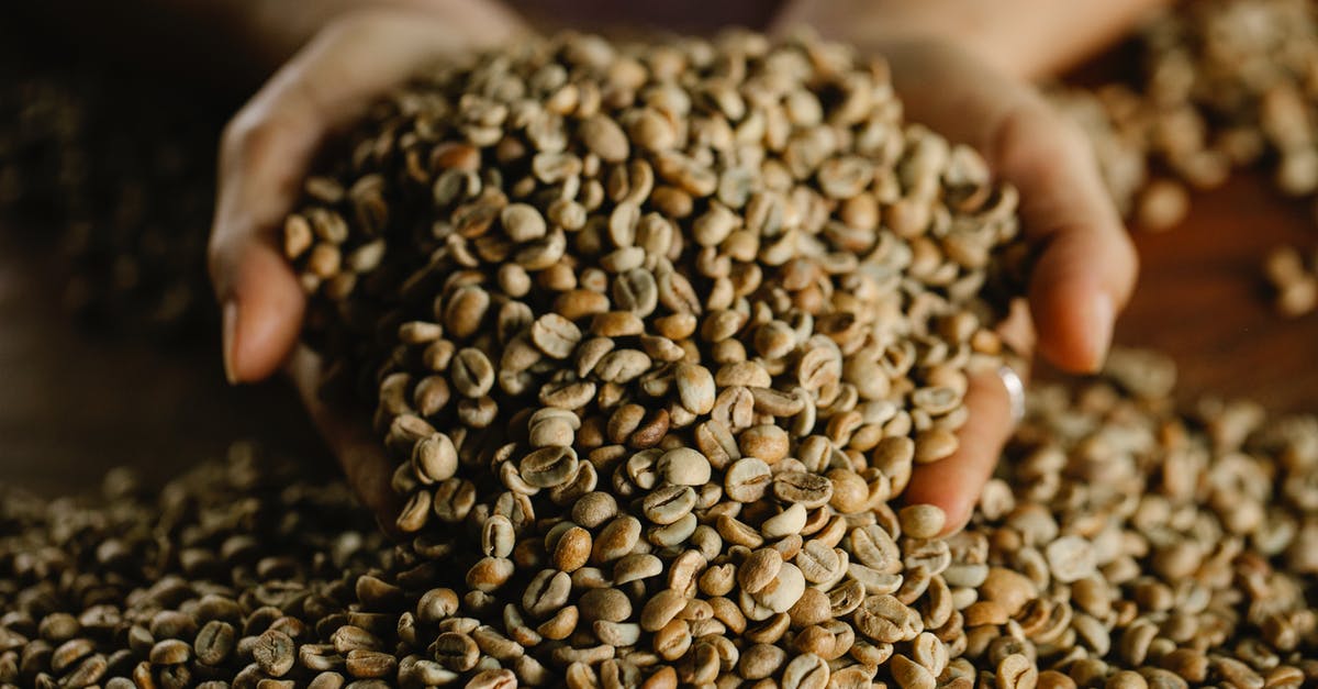 How to remove onions smell from hands? - From above of crop anonymous female demonstrating bunch of fresh raw beans of aromatic coffee scattered on wooden table