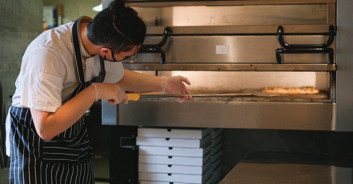 How to remove pizza pan from oven without a peel? - A Man Putting a Pizza in the Oven with a Pizza Peel