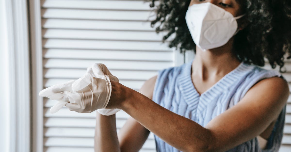 How to remove quinoa bitterness (with many restrictions) doing chapatis - Young African American female in white protective face mask putting of medical latex gloves