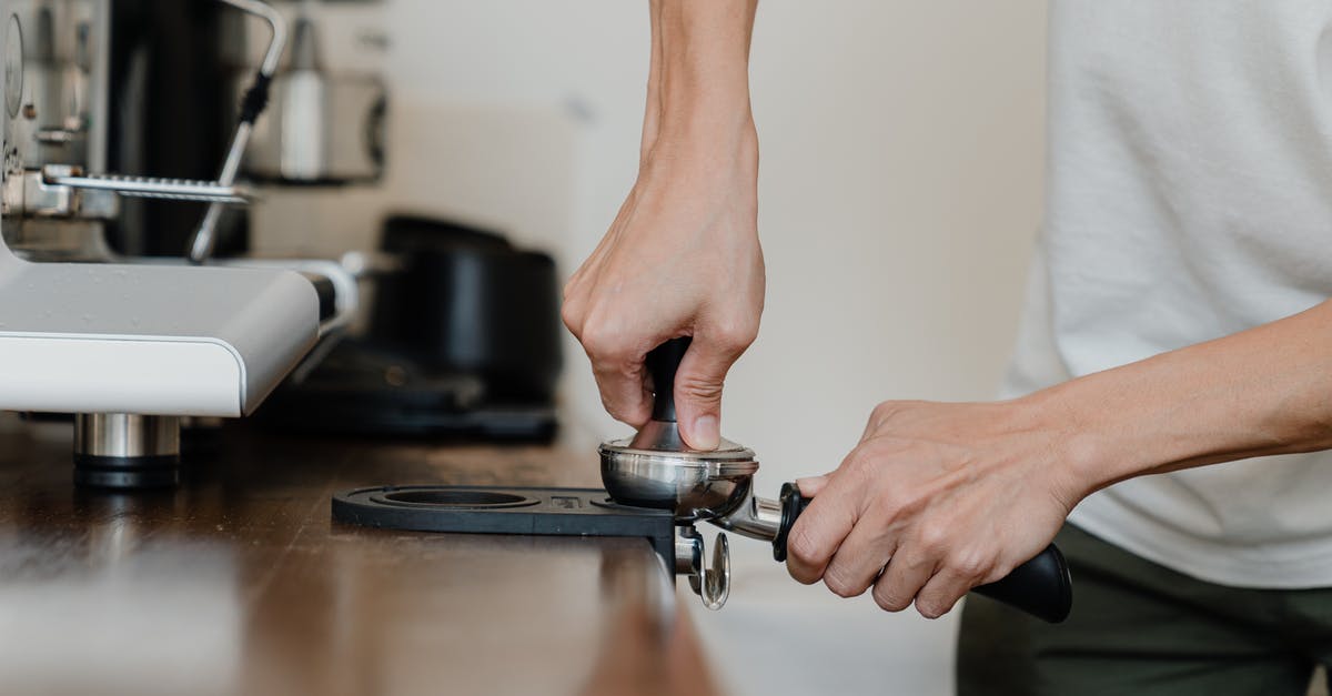 How to remove residual flavours from, e.g., a coffee press - Crop professional barista preparing coffee at wooden counter