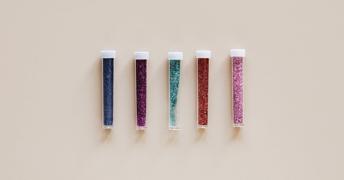 How to remove smell from plastic lid? - From above of transparent narrow plastic tubes with white lids filled with small multicolored shiny beads on beige background