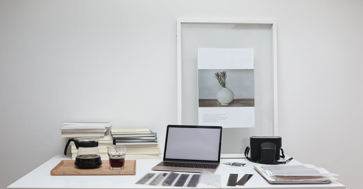 How to reverse sear a steak? - Modern laptop with blank screen arranged with retro filmstrips photo camera and framed picture placed on table near coffee and stack of books