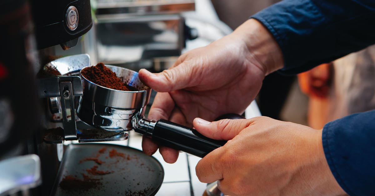 How to select a coffee powder for preparing Turkish Coffee? - Crop barista inserting portafilter into coffee machine at work