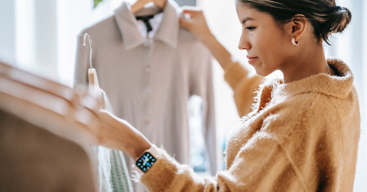 How to select a drain rack for pots and pans? - Crop focused ethnic female in casual clothes choosing apparel while standing near rack in boutique