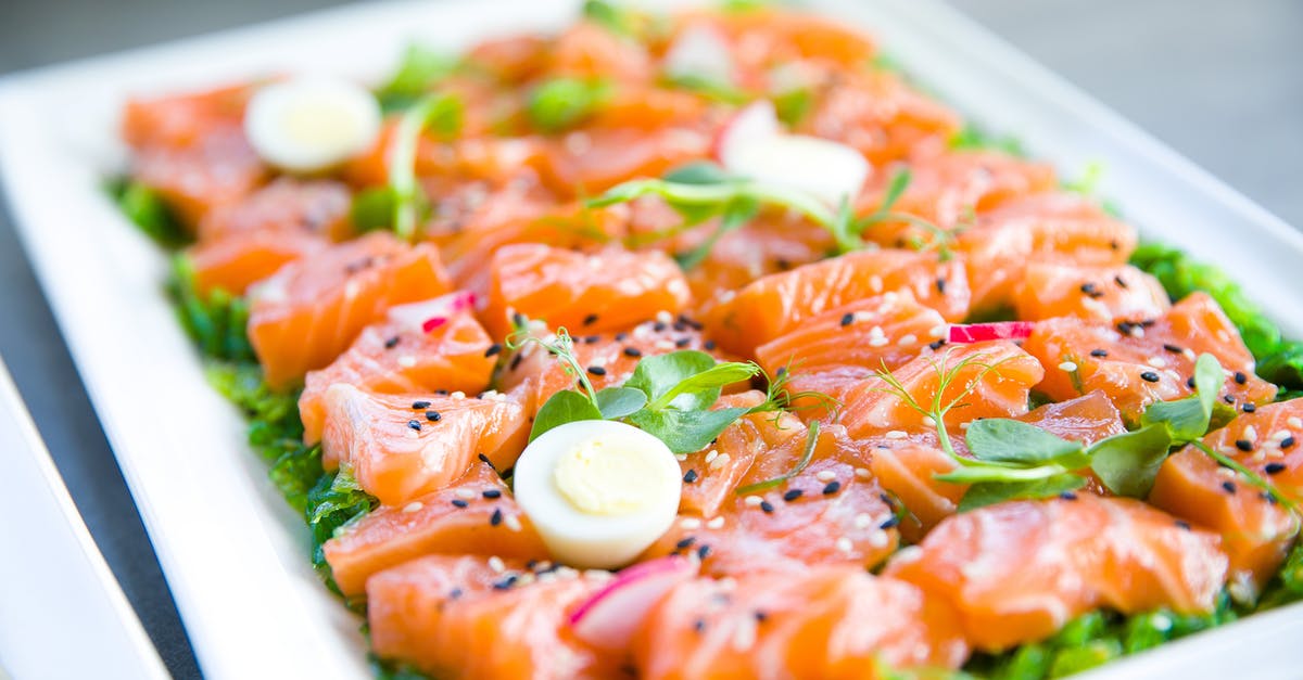 How to serve a fish filet: skin up or down? - Salmon with greens and quail eggs on banquet table