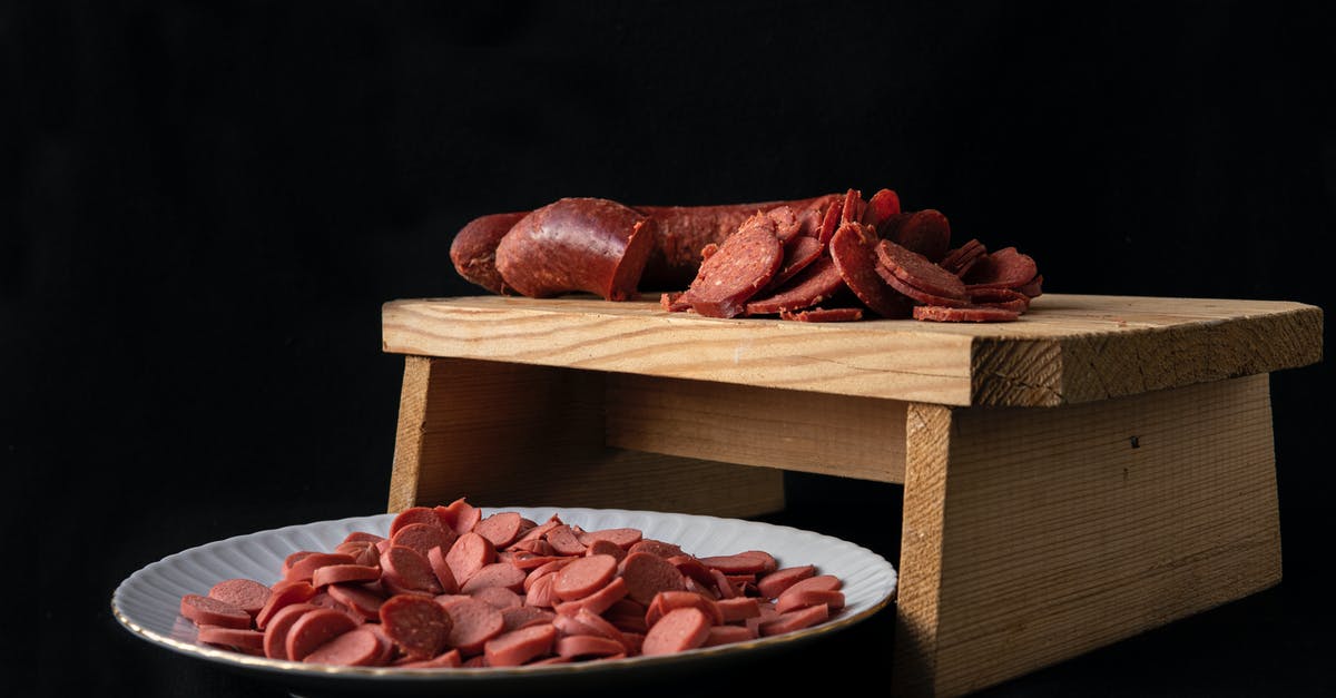 How to slice smoked salmon really thinly? - Delicious cut sausages on cutting board and plate