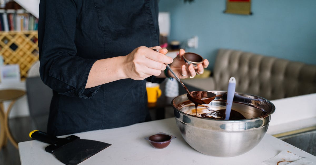 How to solidify melted chocolate? - A Person Scooping Melted Chocolate Into a Small Bowl