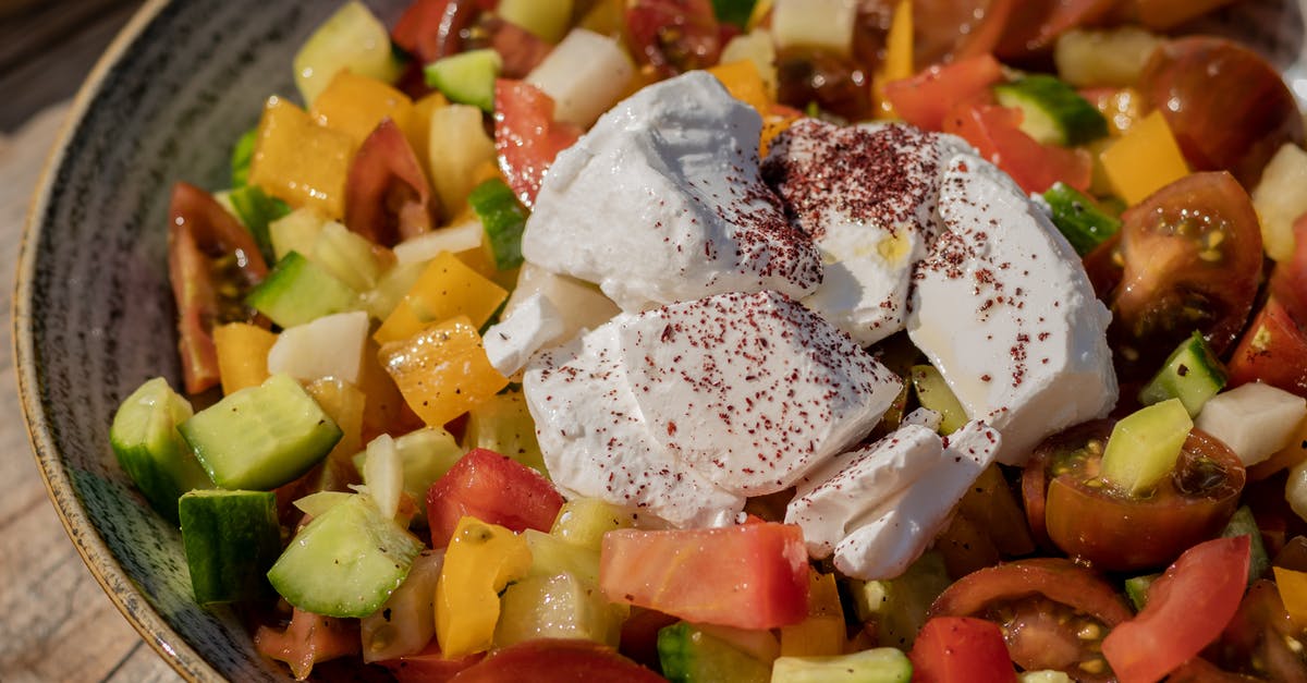 How to stop oil separating from cheese - From above of appetizing fresh healthy vegetable salad with tomatoes and cucumber and sweet yellow pepper decorated with pieces of mozzarella cheese served on ceramic gray plate