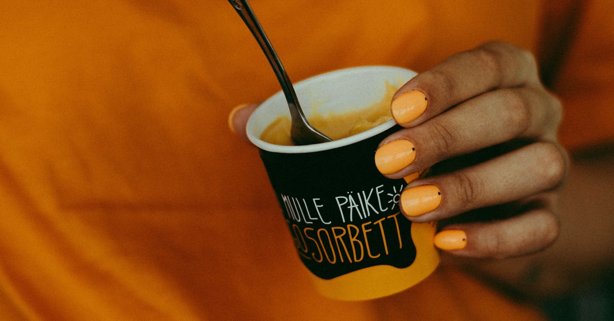 How to substitute oranges in a mango mousse recipe? - Close-up Photo of a Woman Holding a Cup of Mango Flavored Sorbet Ice Cream