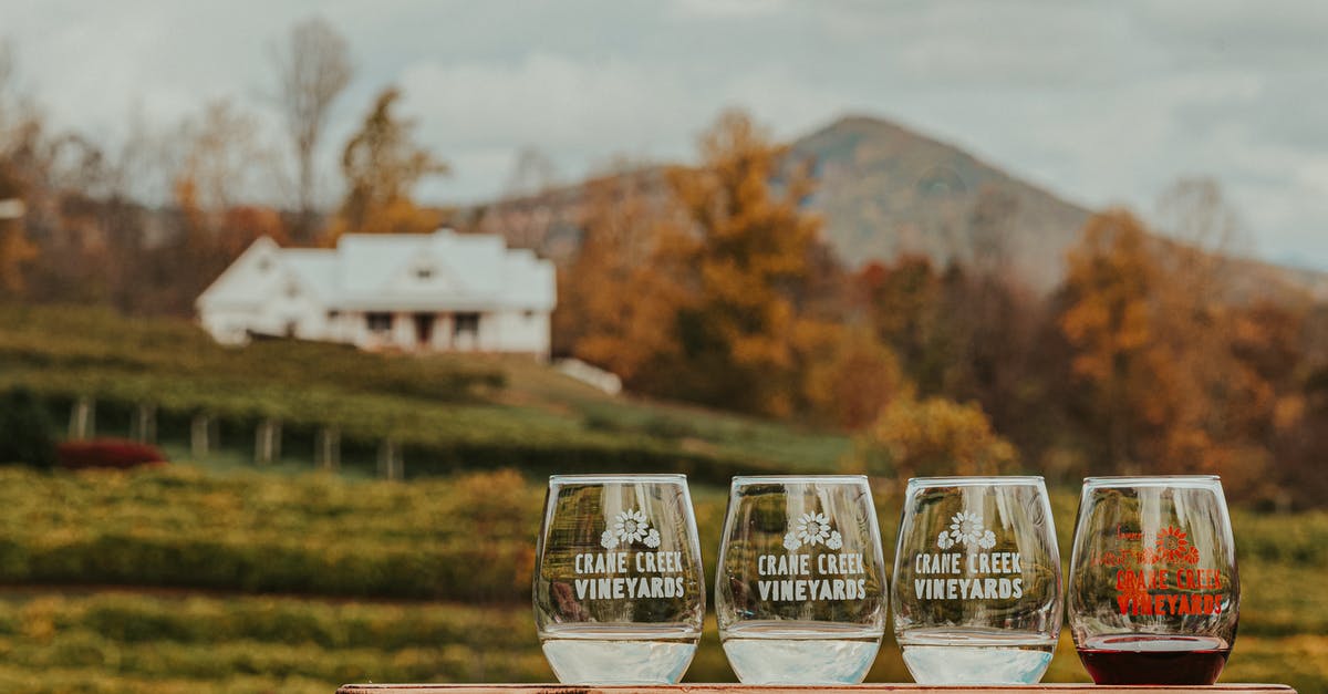 How to taste a real ranch dressing outisde of the US - Crystal glasses of wine placed on wooden table near vineyards located in mountainous countryside against cloudy sky on autumn day