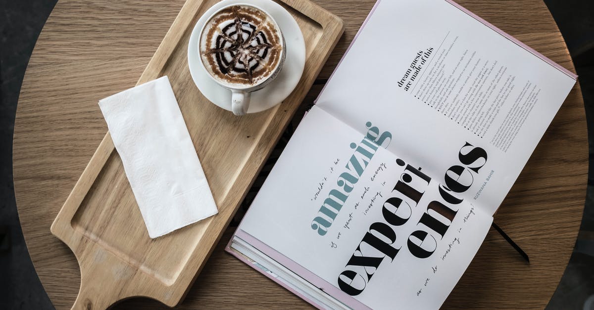 How warm must dough be in order to rise? - Top view of cup of cappuccino garnished with chocolate topping served with saucer and napkin on wooden board placed on cafe round table with open book with amazing experiences title on pages