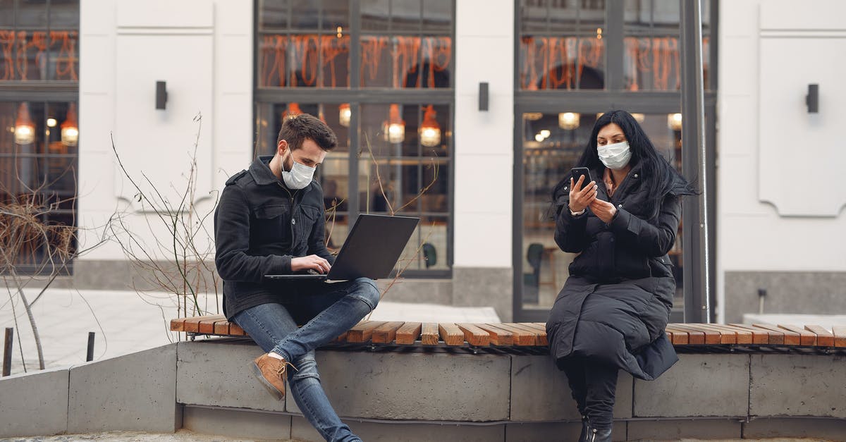 How warm must dough be in order to rise? - Young couple wearing medical masks with laptop and smartphone on city street