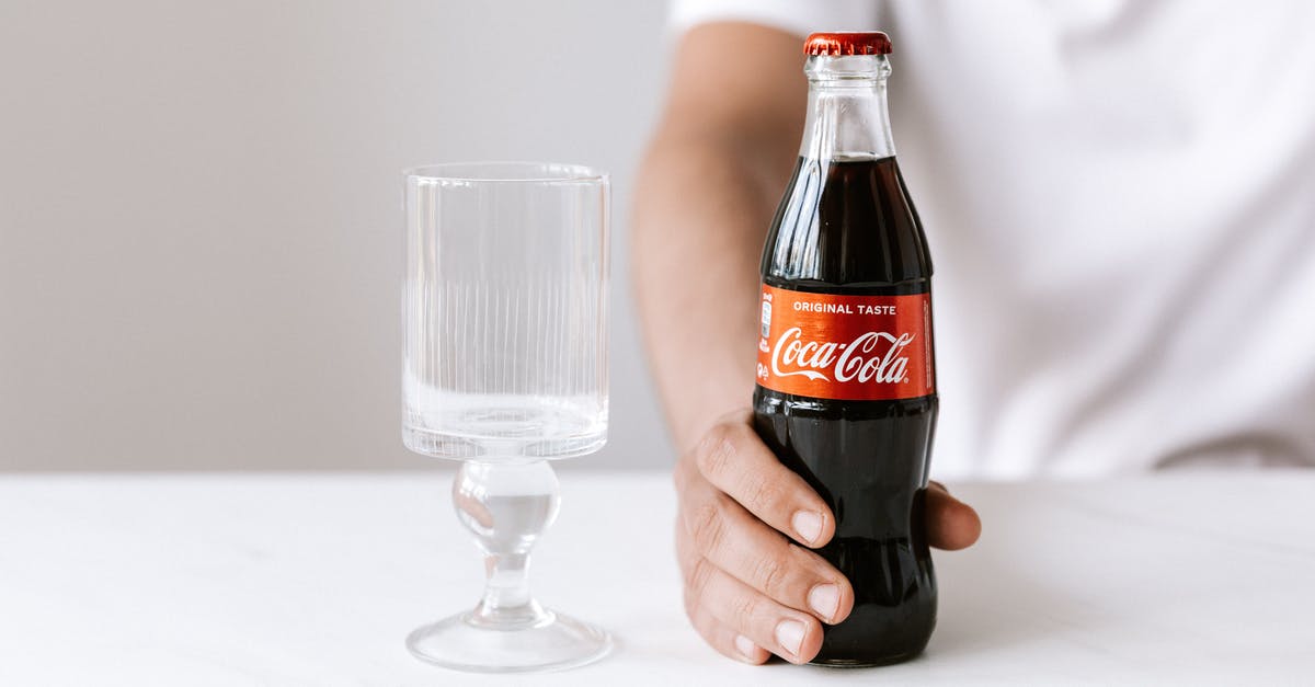 How will reducing and freezing affect the flavor of stock? - Crop unrecognizable young guy in white t shirt demonstrating bottle of cold coke