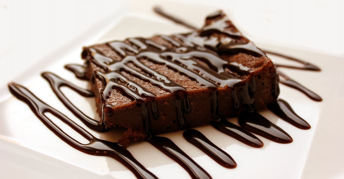 Identify this brownie-like dessert - Chocolate With Milted Chocolate on White Ceramic Plate