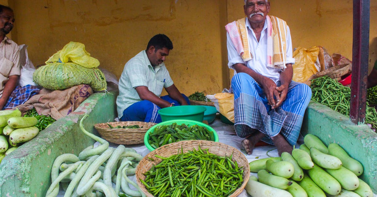 Identifying quality fruits/vegetables at a farmers market - Men Selling Fresh Vegetables