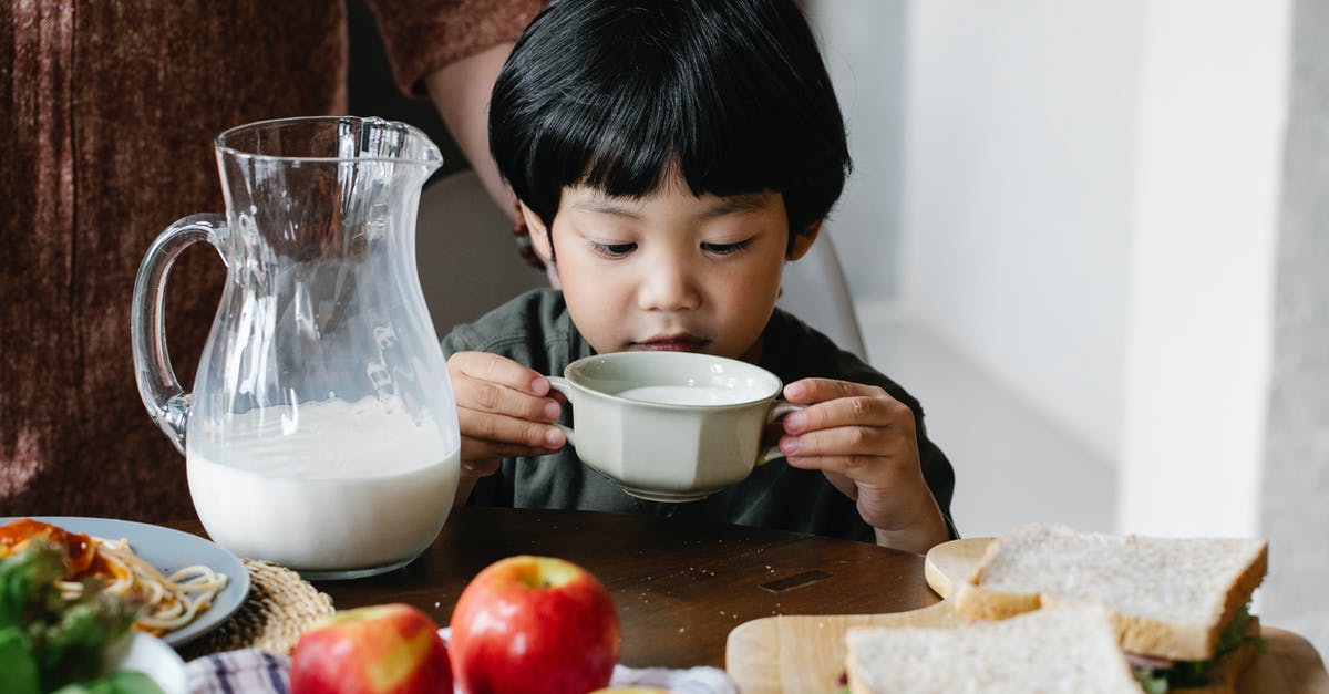 If evaporated milk is mixed with water, does it have the same calcium and vitamin D amounts as regular milk? - Asian boy drinking milk in kitchen