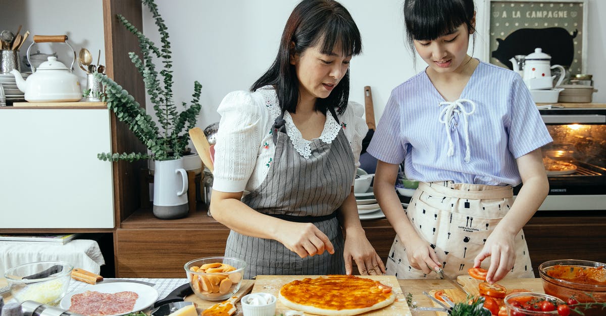 In a tomato sauce recipe, how can I cut the acidity? - Calm women cutting tomatoes on pizza