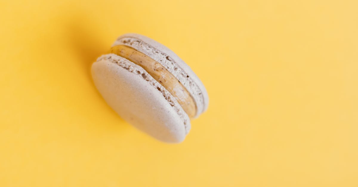 In what proportion should the given ingredients be combined to form a cookie? - From above of delicious round shaped sweet macaroon placed on yellow background of studio