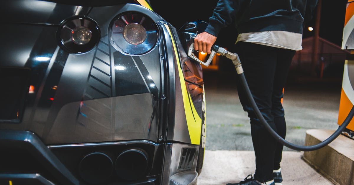 Induction vs. propane gas expense? - Side view of crop unrecognizable male refueling modern racing automobile in petrol station in evening