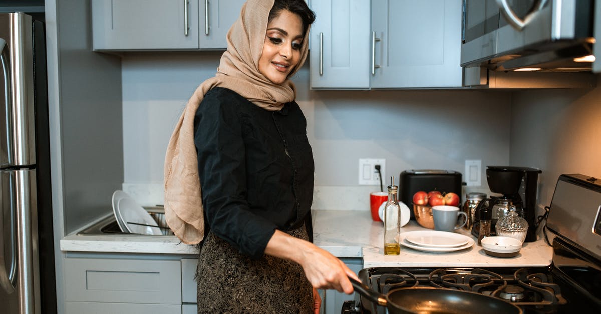 Infrared on regular gas grill - Content Arabic woman with frying pan in modern kitchen