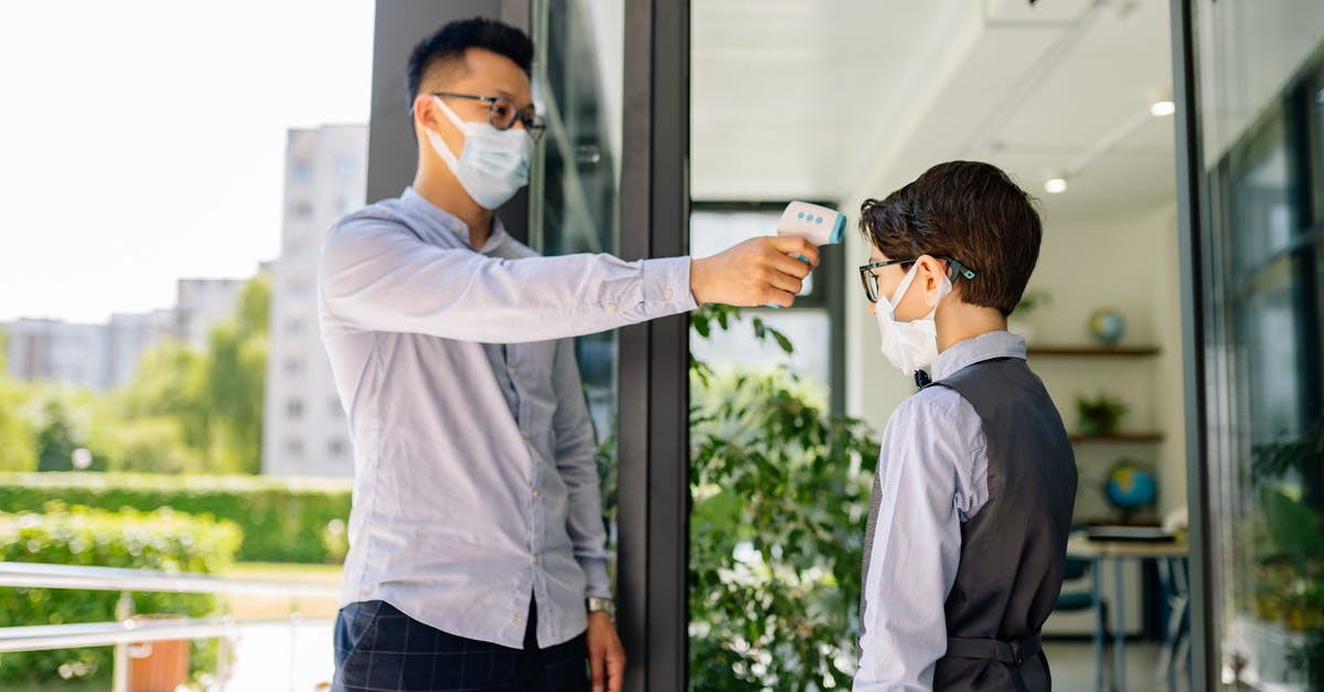 Infrared thermometer for oven temperatures - A Man Checking a Boy's Temperature by a Doorway