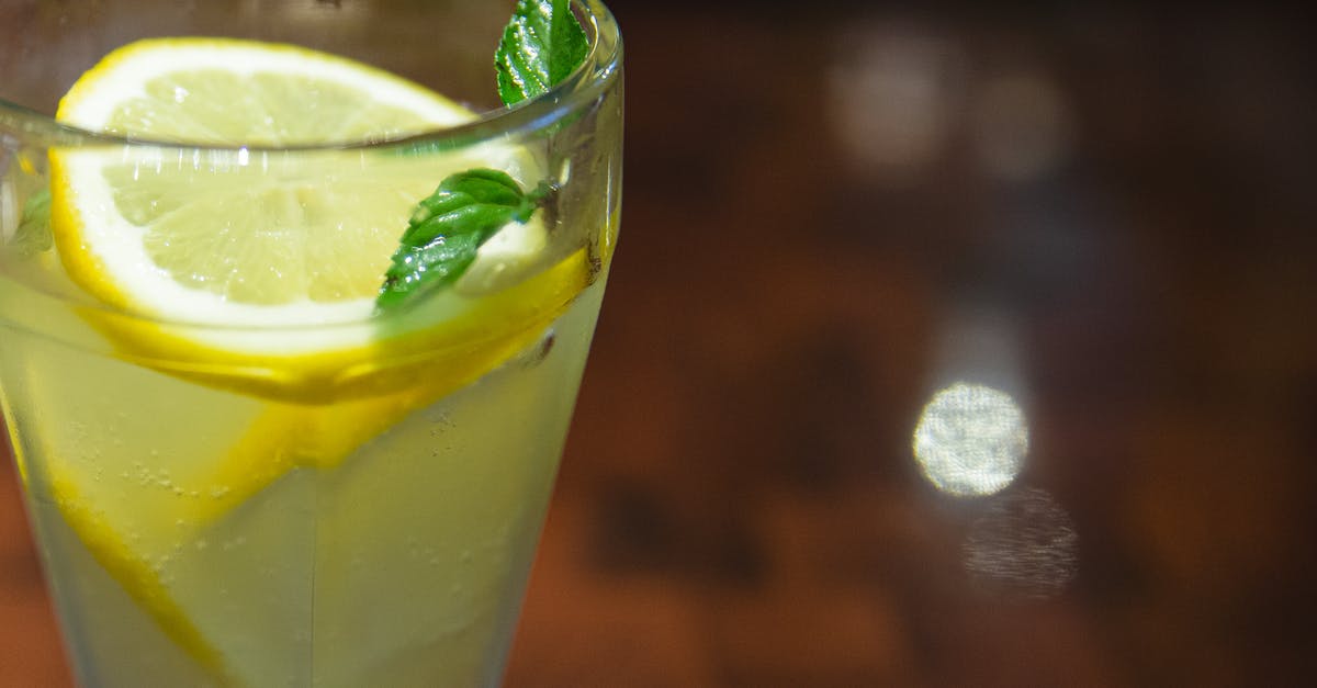 Infuse flavor into dry-mushroom broth - Glass of cold sour lemonade served with lemon slices and fresh mint leaf on blurred wooden table