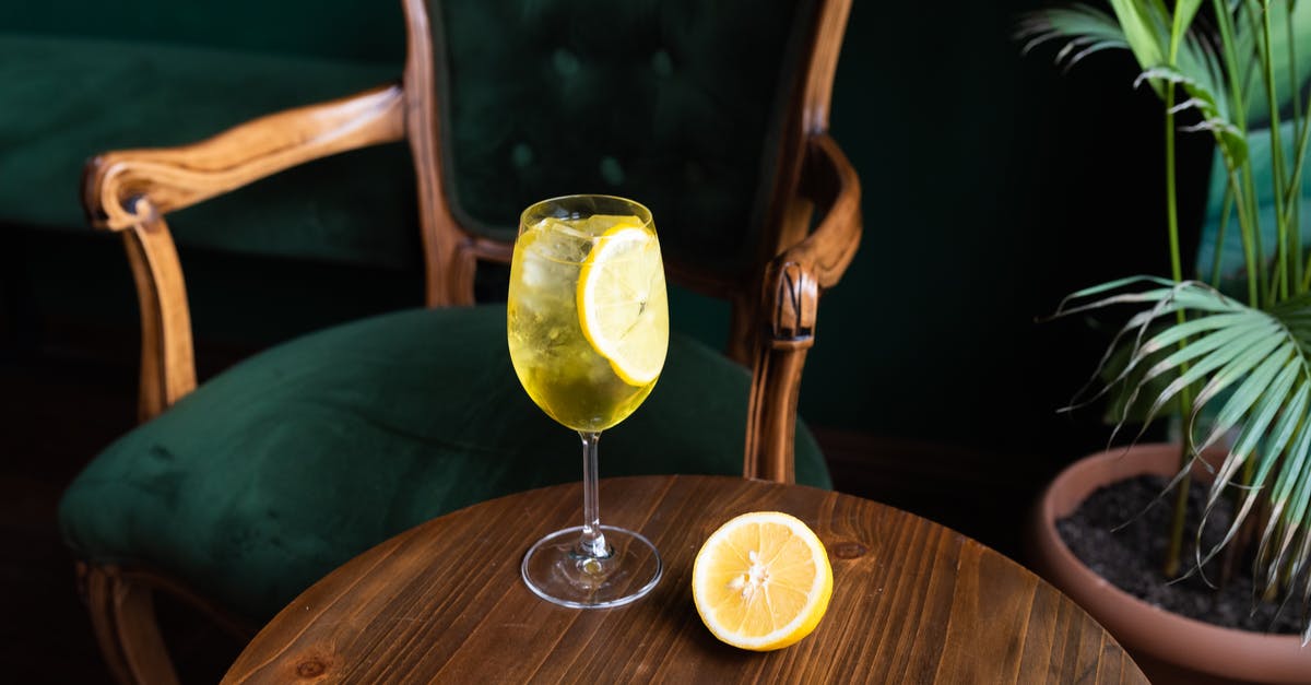 Ingredients for Cocktails - Clear Wine Glass With Yellow Liquid on Brown Wooden Table