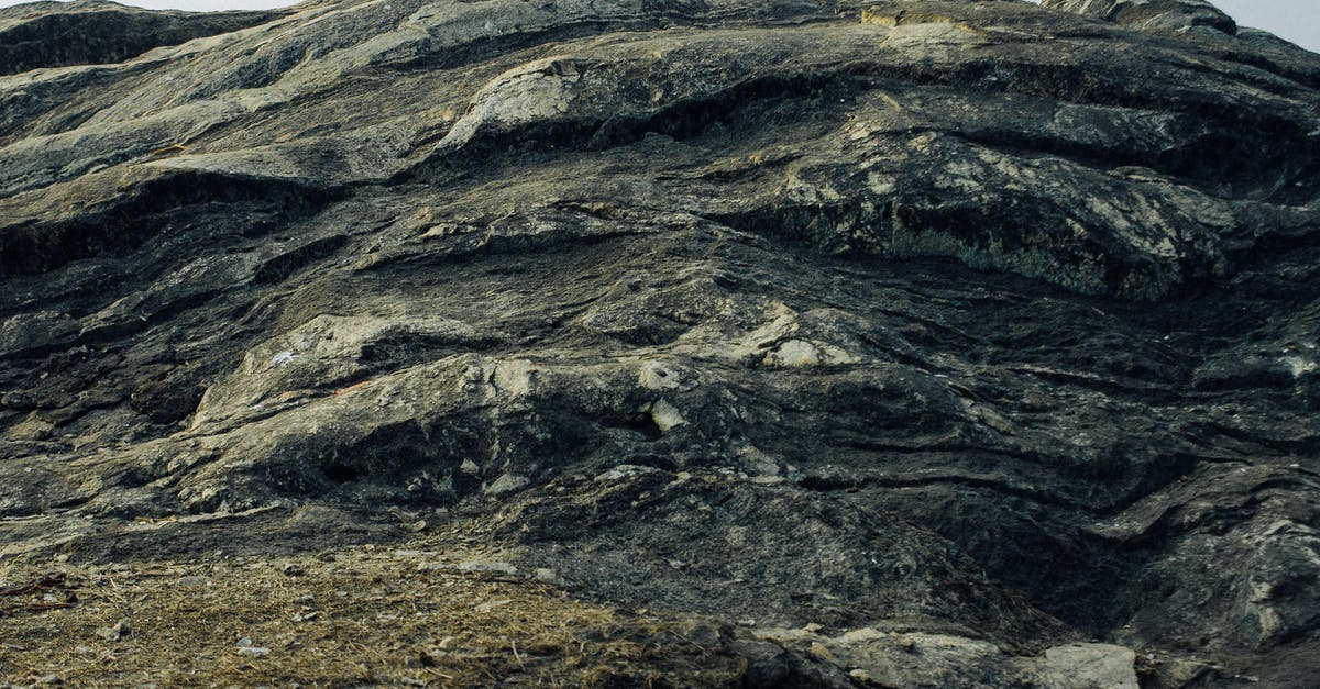 intermittent solid crust on top of yogurt - Low angle of huge hard stone formation with uneven surface located in nature