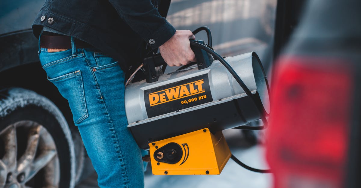 Is a longer defrost better than microwave defrosting? - Faceless man carrying portable heater standing near cars on street