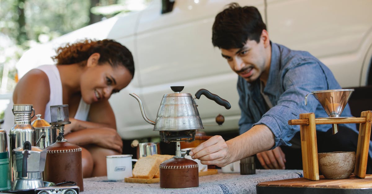 Is boiling water poured over frozen berries enough vs. bacteria? - Diverse couple switching portable stove to boil water during picnic