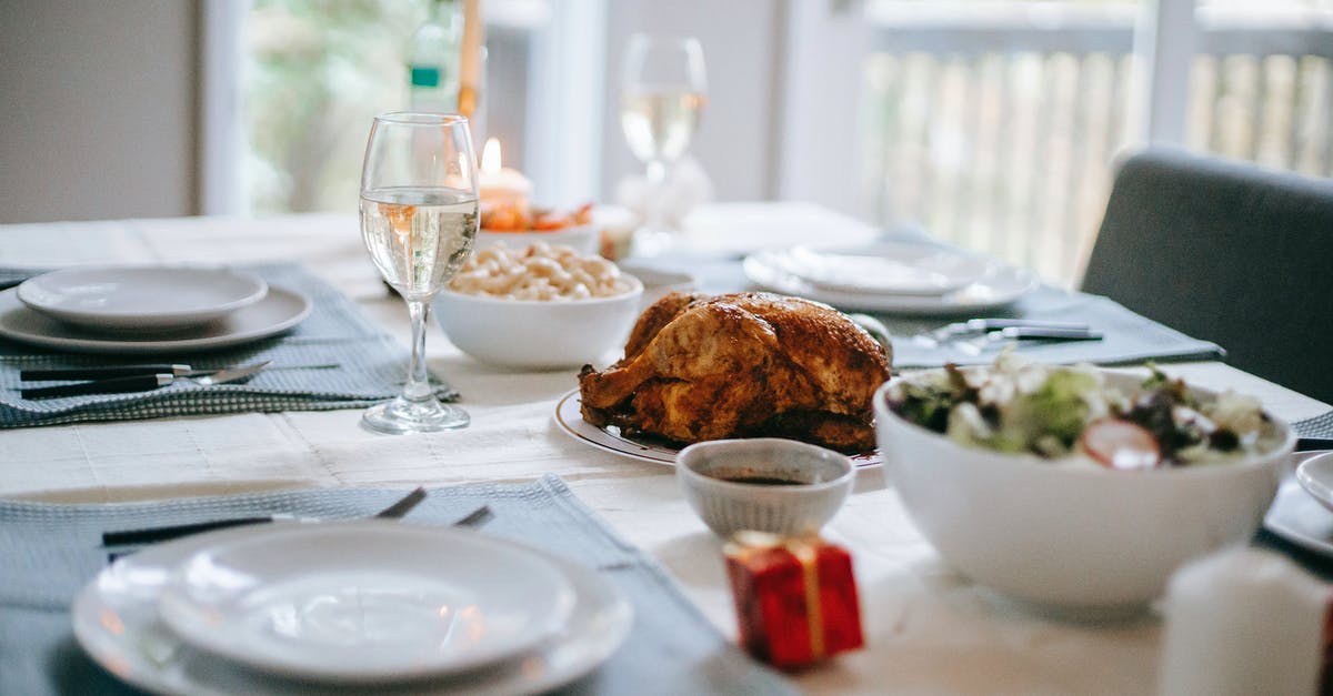 Is carnival glass safe for serving food? - Banquet table with delicious roasted turkey and vegetable salad near dishware during New Year holiday in house