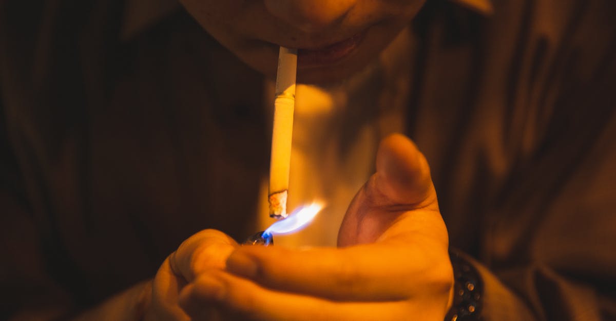 Is it harmful to heat a whetstone? - Crop male with burning lighter and cigarette smoking for reducing stress in light of lamp