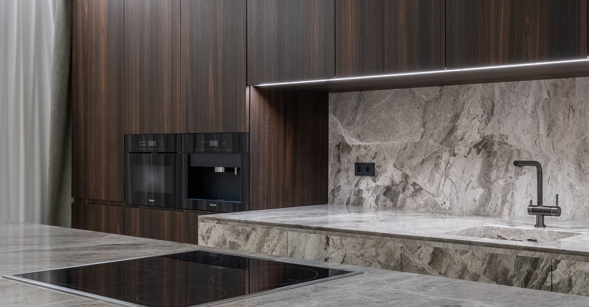 Is it normal to see flames inside my self-cleaning oven? - Interior design of spacious stylish modern kitchen with induction stove and air extraction system with wooden cupboards