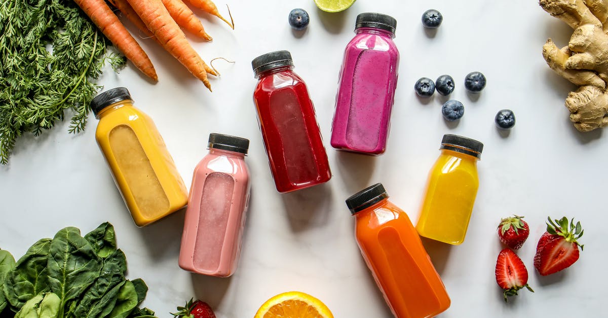 Is it OK if your pressed ginger juice has a pancake batter like consistency? - Colorful Bottles with Smoothies Beside Carrots, Ginger, Leaves and Berries