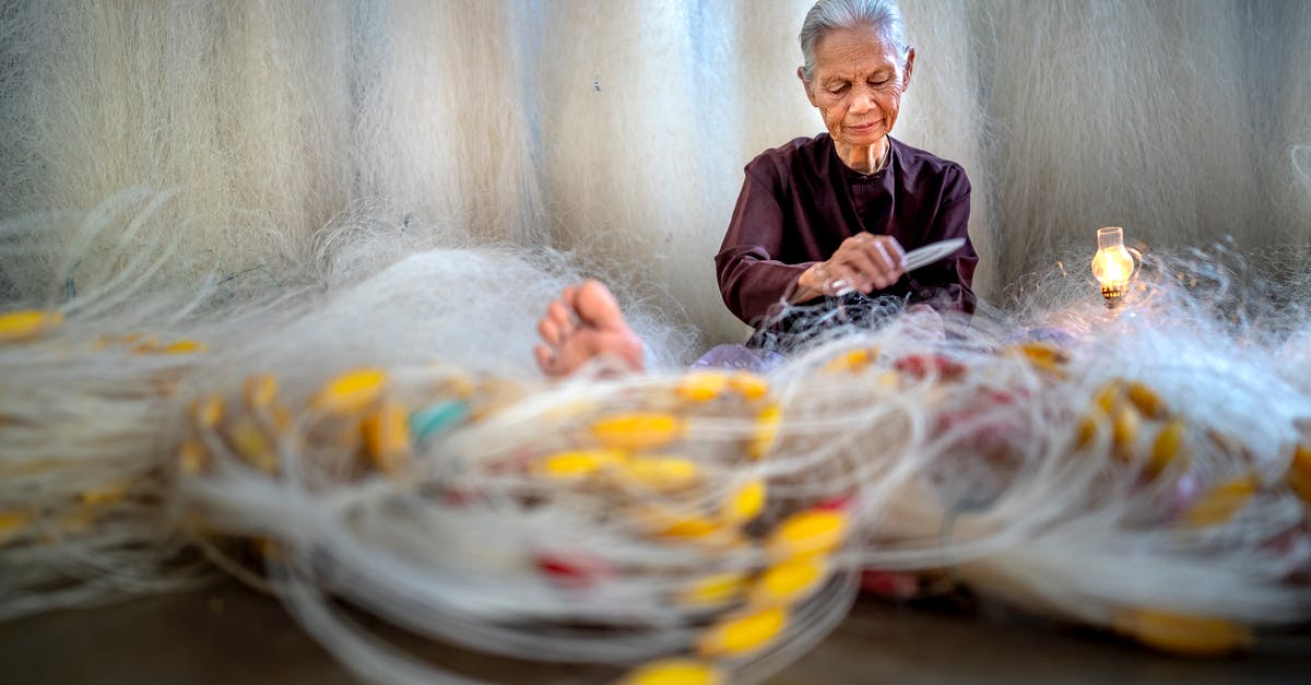 Is it possible to make a Dutch baby, or similar, without an oven? - Elderly Asian woman repairing fishing net against lamp